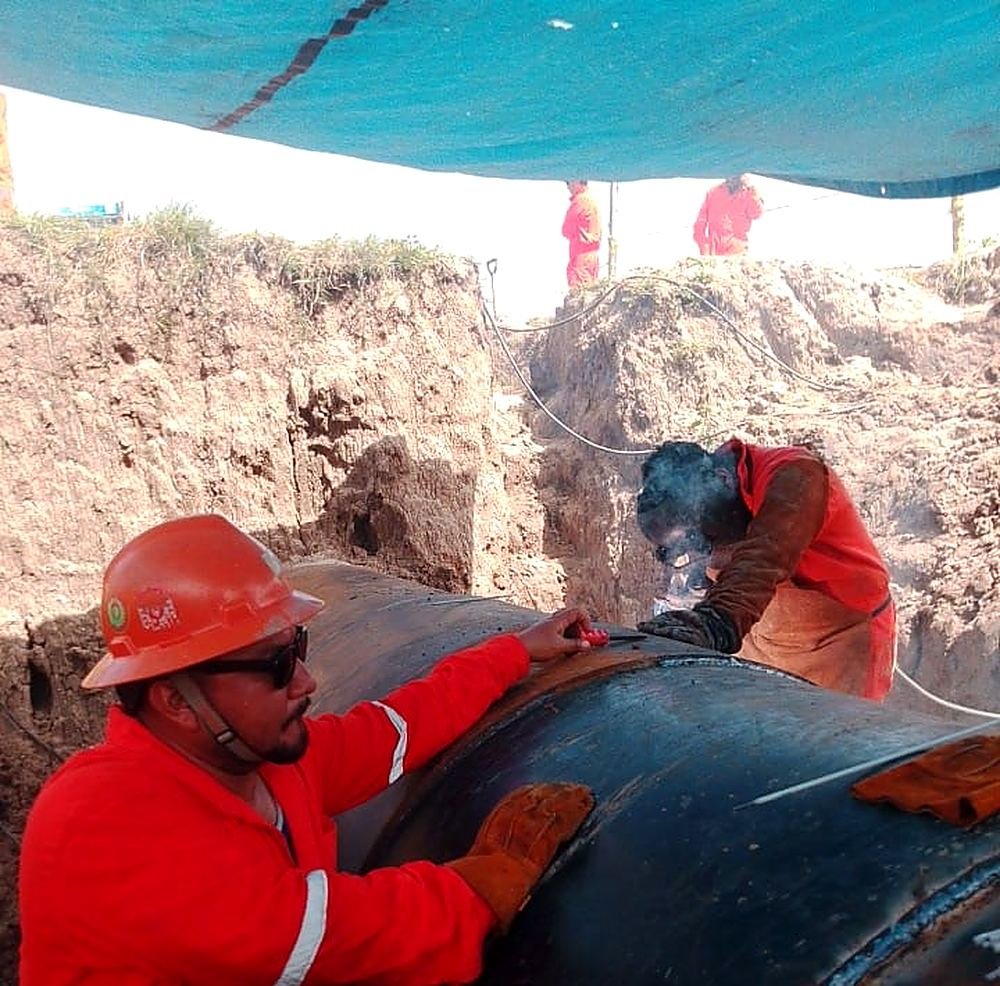 Soldador uniendo un tramo de ducto en zanja, Veracruz