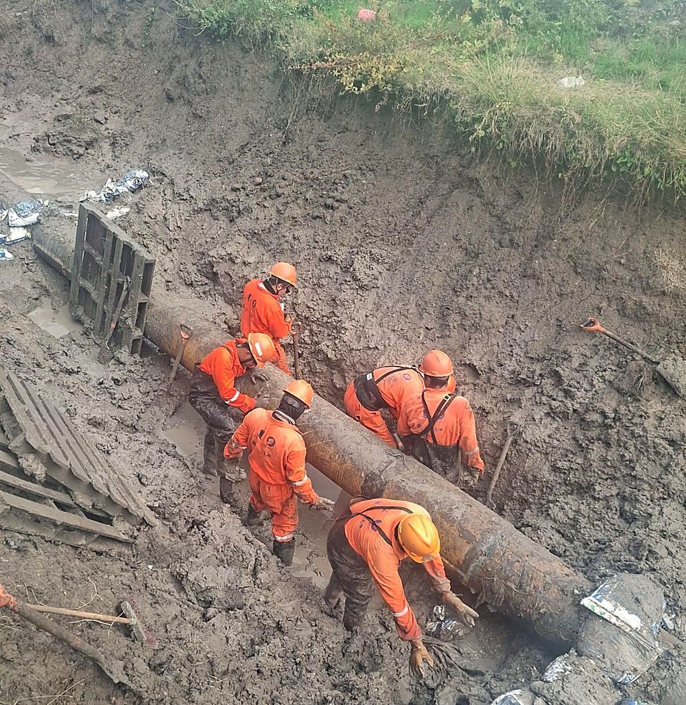 Cuadrilla manipulando un ducto en zanja durante mantenimiento