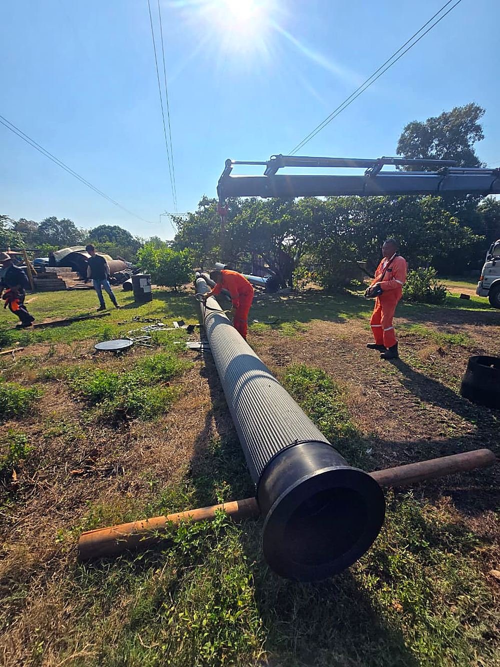 Cuadrilla trabajando en el tendido de un poliducto en campo